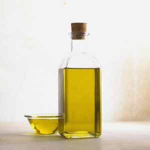 Bottle of ear drops next to an ear, demonstrating the proper application for earwax softening at home