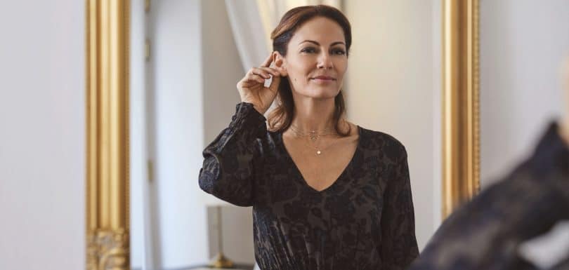 Woman confidently wearing a discreet hearing aid after a professional hearing test at Kensington Hearing London.